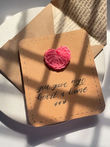 Another angle of the crochet heart card, showing the texture of the paper and the handmade envelope it comes with.