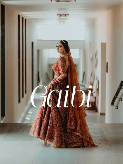 A full-length portrait of a bride in her stunning red wedding lehenga, looking back with elegance.