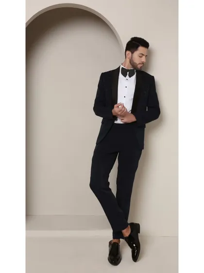 The relaxed yet confident stance in the Prism Riviera tuxedo. The custom tailoring ensures a perfect fit, allowing the unique beadwork and rich teal color to take center stage.