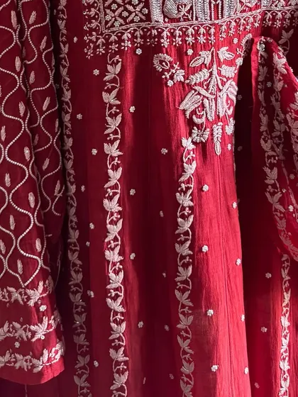 A detail shot of the Anarkali's flare, showcasing the vertical vine-like patterns and scattered motifs that add to its elegance.