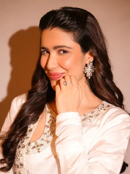 A soft and angelic look. The makeup here is minimal and fresh, with a focus on glowing skin and a gentle pink lip to complement the white embellished outfit.