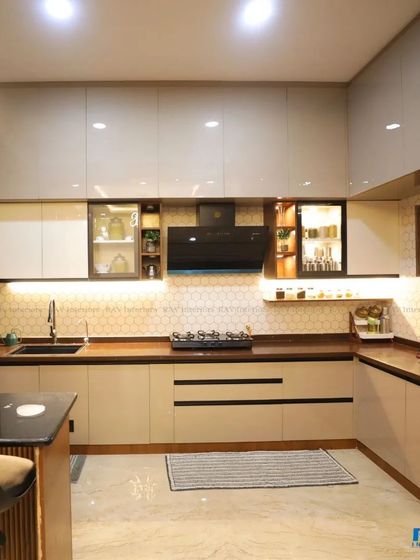 Another angle of the beige and wood kitchen, showcasing the high-gloss cabinets, black chimney, and under-cabinet lighting that makes the space both functional and beautiful.