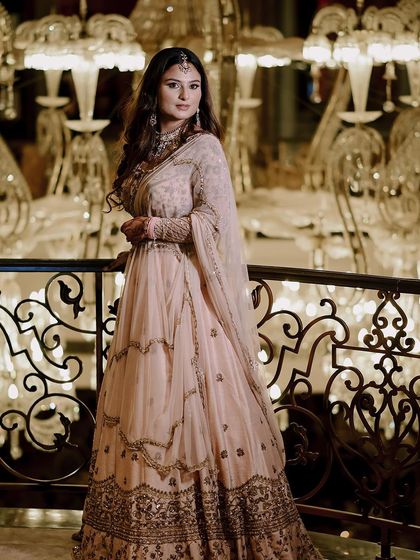 A full-length portrait of Ashi against a backdrop of grand chandeliers, highlighting the luxury of the event.