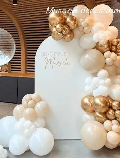 A classy and neutral-toned balloon decoration. The white arched backdrop is framed by a beautiful garland of white, cream, and chrome gold balloons, perfect for a baptism, naming ceremony, or elegant birthday.