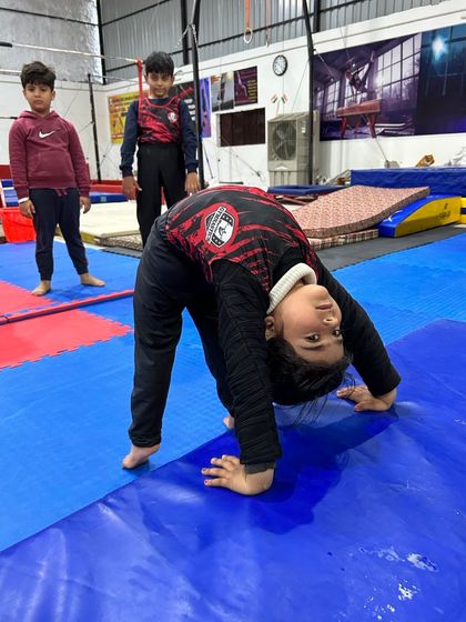 Even our youngest athletes learn the importance of flexibility. This little gymnast is practicing her bridge, showing great potential and form at an early age.