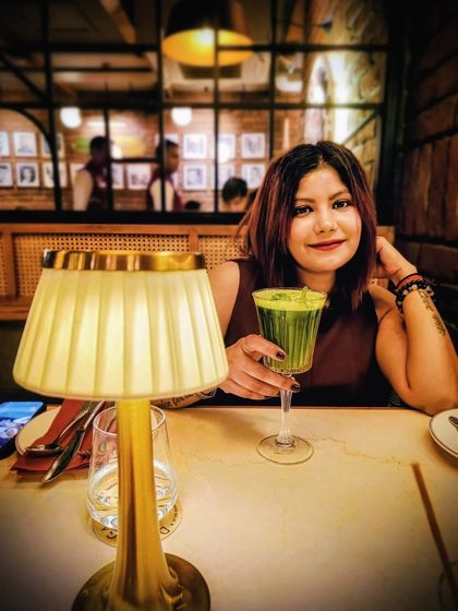 Enjoying a drink at a restaurant, this close-up shot has a warm, intimate feel, perfect for showcasing a dining experience.