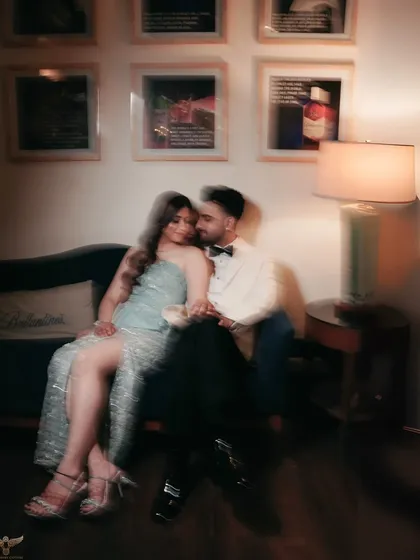 An artistic, motion-blur photo of the couple sharing an intimate moment on the couch. This creative technique adds a dreamy, romantic feel, suggesting a private moment in a bustling room.