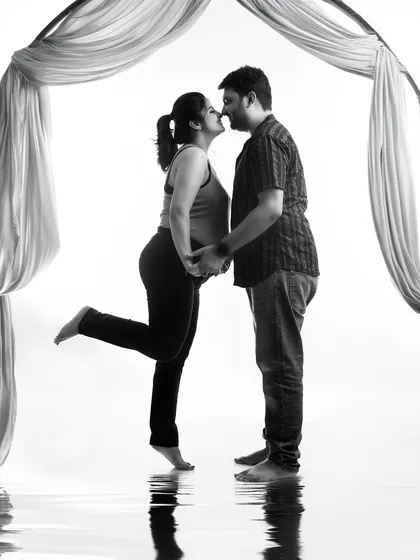 A playful and romantic black and white silhouette. The 'almost kiss' pose and the water reflection effect create a fun and artistic image of the couple's connection.