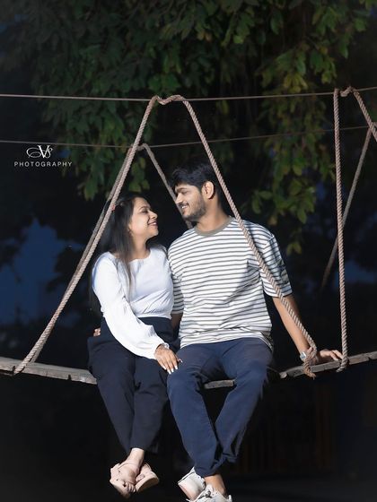 A romantic pre-wedding shot of a couple on a rope bridge at night, creating a magical and adventurous atmosphere.