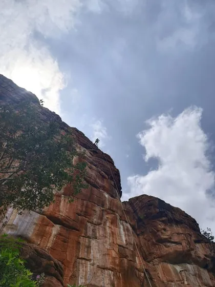 The exhilarating descent. A participant rappels down a massive rock face in Badami, taking in the breathtaking views. Rappelling is a key skill we teach in our courses, essential for safely navigating vertical terrain.