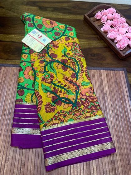 A unique Kalamkari print on a yellow-green Mysore silk saree with a purple border.