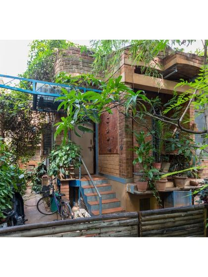 The lush, green entrance to the Sans Souci Residence, our first experimental home. The building is designed to be a part of the ecosystem, with vegetation growing on and around it, attracting diverse birds and insects.