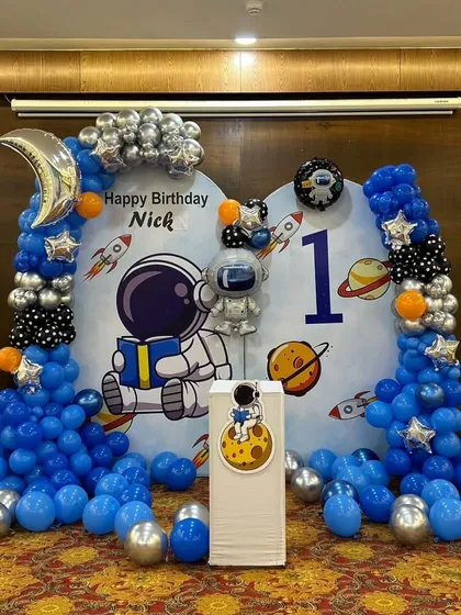 The full astronaut decoration, showing the balloon columns and floor balloons that create an immersive space environment.