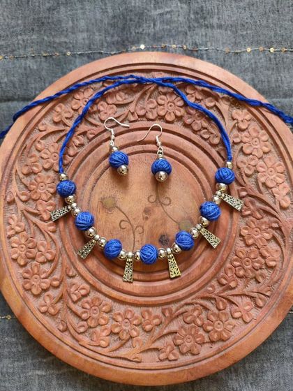 This thread bead necklace is available in a variety of colors like orange, green, yellow, blue, and red. It's a simple yet elegant accessory, perfect for adding a pop of color to your festive wear.