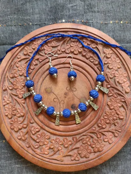 This thread bead necklace is available in a variety of colors like orange, green, yellow, blue, and red. It's a simple yet elegant accessory, perfect for adding a pop of color to your festive wear.