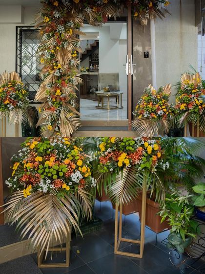 A collage of the beautiful and rustic floral decor for an intimate home wedding. The golden-painted leaves and vibrant flowers created a warm and welcoming atmosphere.