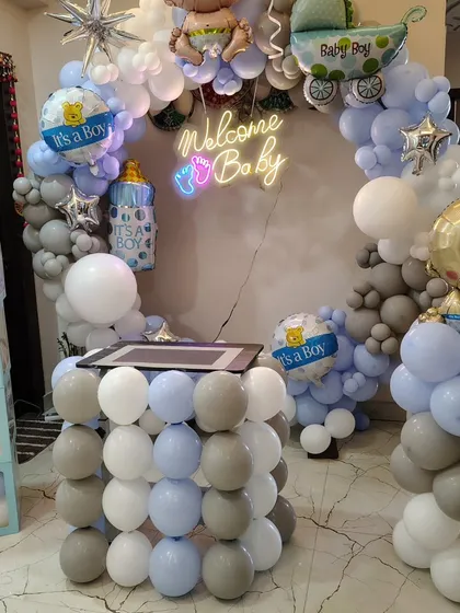 A detailed shot of the "Welcome Baby" boy setup, including the balloon-wrapped table and columns.