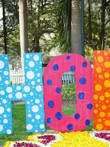Large, custom props are perfect for photo opportunities and brand visibility. These oversized, polka-dotted "HOLI" letters provided a fun, interactive centerpiece for an outdoor corporate celebration, surrounded by a bed of flower petals.