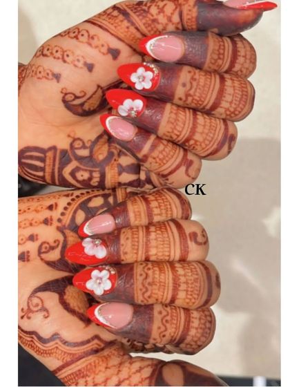 A creative shot of the red and white 3D flower bridal nails.