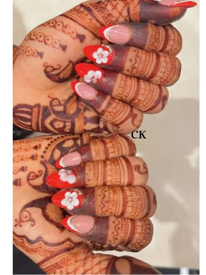 Two hands together, showcasing the complete red and white floral bridal nail set. It's a classic and vibrant look for any wedding celebration.