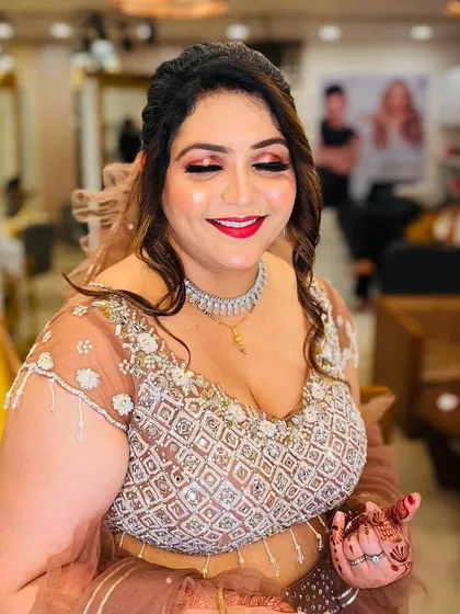 This client is all smiles, ready for her event. The makeup features a classic red lip and a warm, shimmery eye that makes her glow.