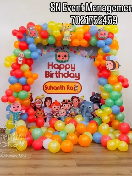 This Cocomelon setup features a full balloon frame around a custom "Happy Birthday" banner. The floor is covered with colorful balloons, creating a playful area for the kids.