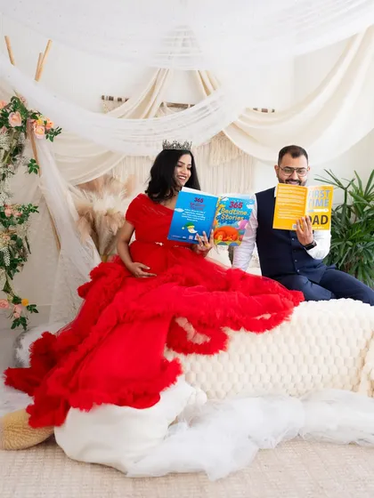 Getting ready for parenthood. This sweet and fun shot shows the couple reading parenting and children's books in our cozy studio bed setup.