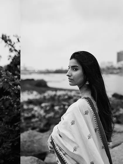 A quiet moment by the sea in Mumbai, captured in black and white. The monochrome treatment gives the scene a timeless, nostalgic quality, focusing on the model's profile and the soft, overcast light.