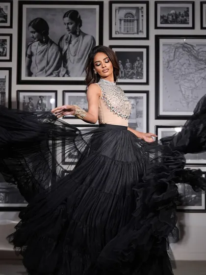 A full-length shot showing the drama and movement of the black tulle skirt. The makeup is bold and confident.