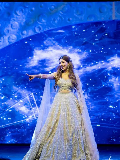A bride commands the stage during her solo performance against a celestial backdrop. We ensure you are the star of the show.