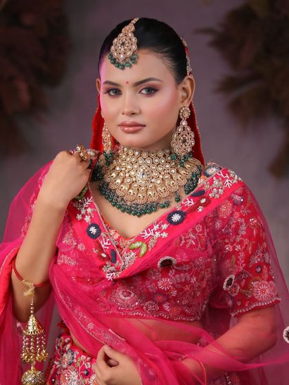 From learners to artists. Our students master the art of bridal makeup, creating breathtaking looks like this one with a vibrant pink lehenga and heavy kundan jewelry.