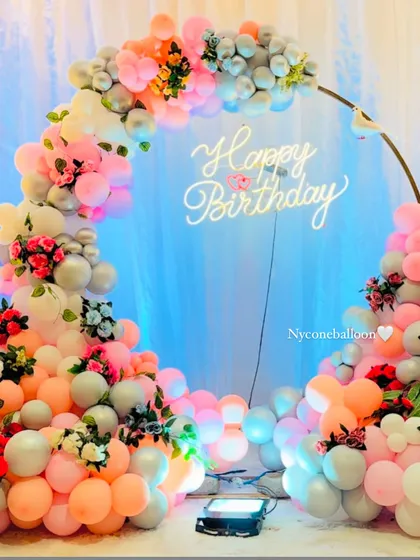This beautiful and delicate birthday setup features a balloon ring in soft pastel shades of pink, peach, and grey. I added small floral arrangements and a classic 'Happy Birthday' neon sign to complete the dreamy, romantic look.