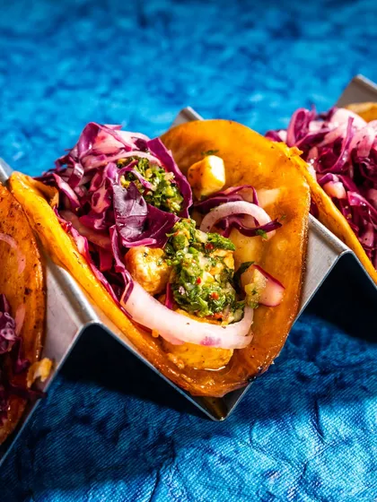 Vibrant, bold, and full of flavor. This close-up of tacos for Nacho Mama uses dramatic lighting and rich colors to create a powerful image that jumps off the screen, ideal for social media and promotional materials.