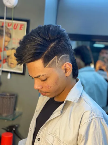 This modern mullet is taken to the next level with a sharp, lightning-bolt style design carved into the fade.