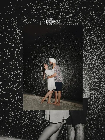 An artistic shot of a couple embracing, framed by a creative 'fake snow' effect against a black background.
