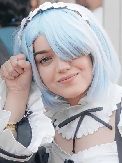 A close-up portrait of the Rem cosplayer. This shot focuses on her expression and the details of her wig and costume, showing the artistry involved.