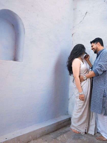 A quiet, intimate moment during a pre-wedding shoot. The simplicity of the white walls draws all the focus to the couple's connection.