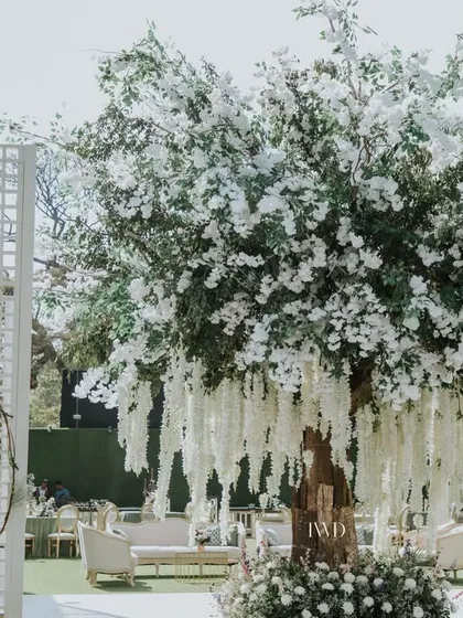 A different take on the 'Tree of Life' concept for a vintage-themed garden wedding. This installation feels organic and integrated with the natural surroundings, perfect for an elegant outdoor event.