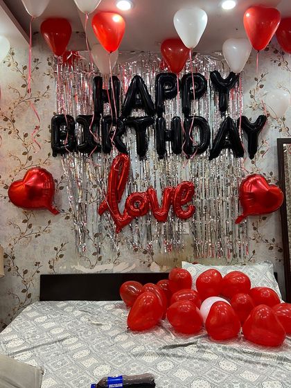 Another view of the complete birthday setup, showing how the combination of ceiling balloons, wall decor, and balloons on the bed creates a full-room experience.