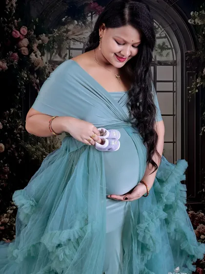 A close-up on the baby bump with a pair of tiny shoes. This is a classic, must-have shot for any maternity session, full of emotion and hope.