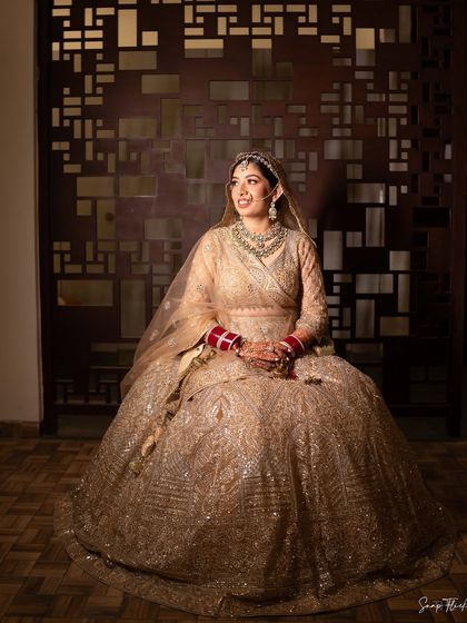 A full-length portrait of Ria, showcasing her entire bridal ensemble. Her makeup was designed to be impactful from a distance yet beautifully detailed up close.