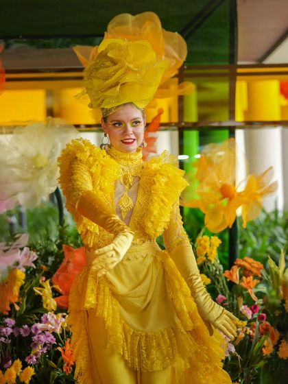 A performer in an elaborate, custom yellow costume, embodying the "yellow extravaganza" theme of the Haldi celebration.