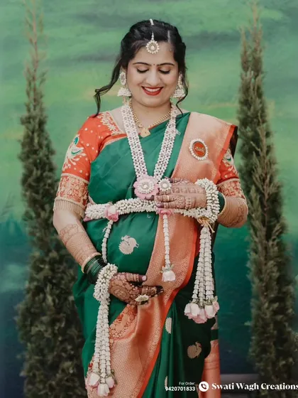 A moment of reflection. The layered floral necklace and matching maang tikka create a cohesive and elegant look.