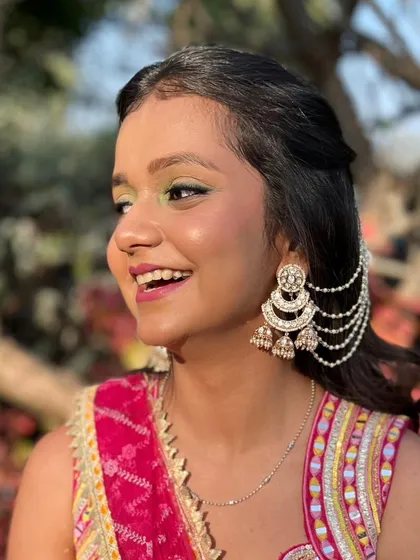 A happy and smiling client, showing off her unique and beautiful eye makeup.