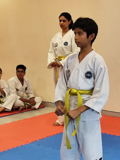 A student stands at attention during his belt grading exam, demonstrating focus and discipline.
