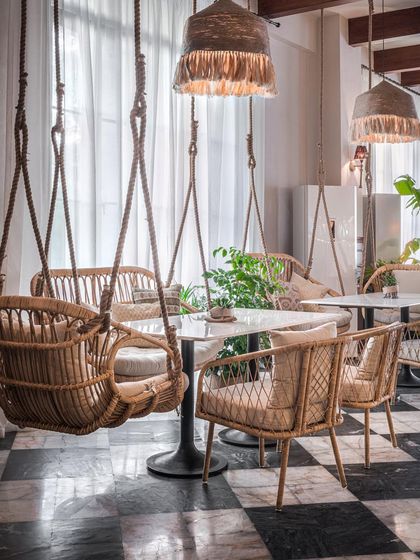 At the EVE restaurant, we used versatile seating options like these charming wicker swings to cater to various moods. The design combines natural textures with a classic black-and-white checkered floor, creating a space that feels both playful and timeless.