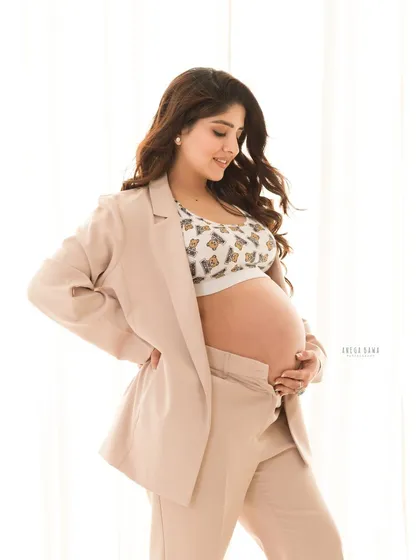 A modern and chic solo portrait. The combination of a stylish pantsuit and soft, even lighting results in a sophisticated and contemporary maternity photo.