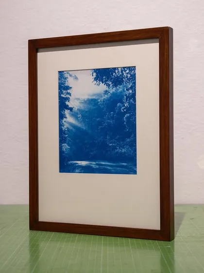 The framed print of the sunlit forest path, part of a custom set of cyanotypes created for a client's home.