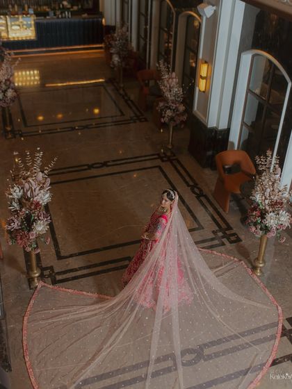 A high-angle shot showcasing the bride's magnificent veil, spread out to its full length in a beautifully decorated hotel lobby.