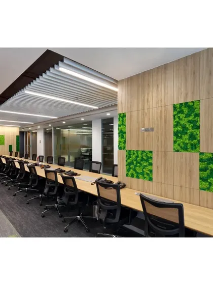 A long meeting table featuring biophilic design with integrated green moss wall panels. This element introduces a natural texture into the corporate environment, promoting wellness and reducing stress.
